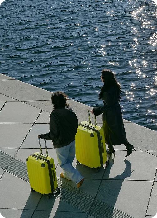 Zwei Reisende mit knallgelben Koffern am Berliner Ufer – Link zur Kategorie Special Editions