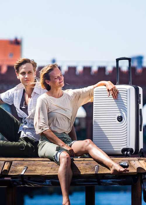 Young couple sitting with a Hauptstadtkoffer from the Mitte suitcase series
